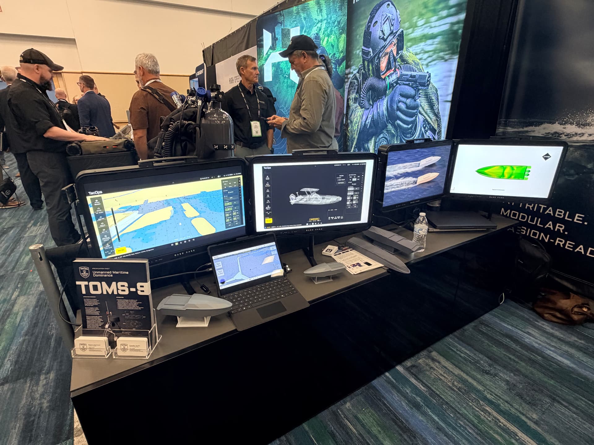 TOMS-9 specification display and TacOps control-station screens at the SOF Week 2026 booth