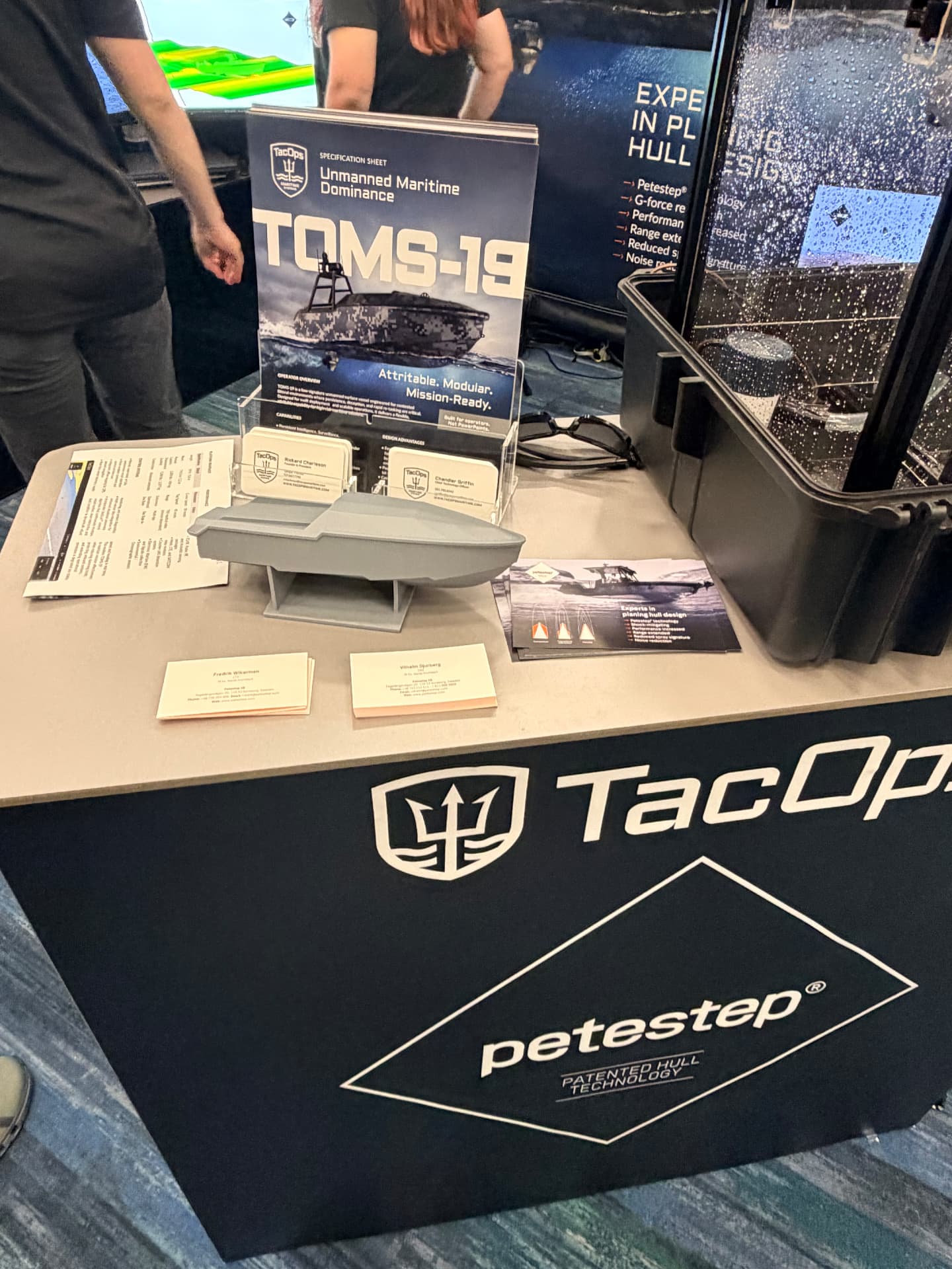 TOMS-19 specification sheet and scale model on the TacOps booth table at SOF Week 2026